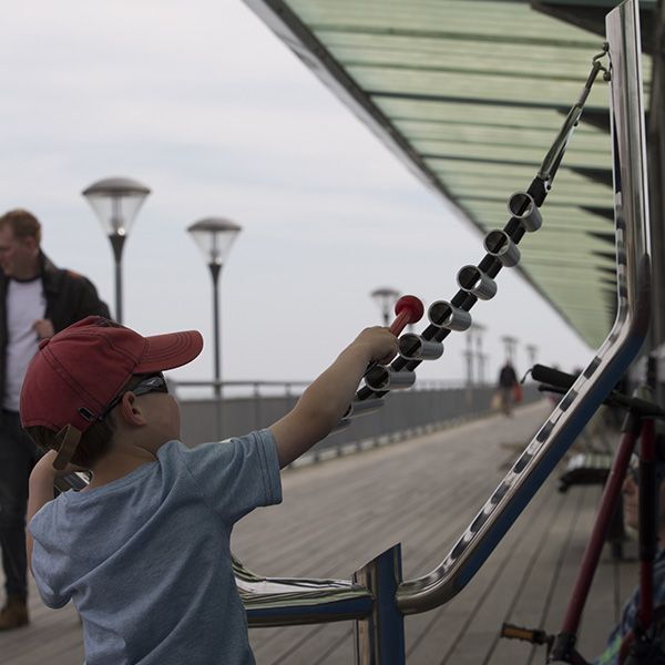 Small Boy in Cap and Sunglasses Playing Large Xylophone on Boscombe Pier 