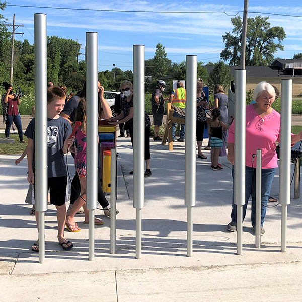 tall silver tubular bells on the bridge to bay cycle trail in michigan