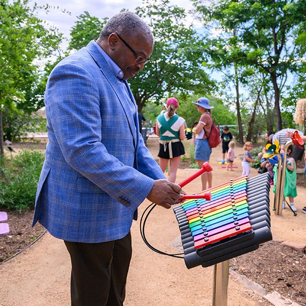 the president of the acm playing a colourful outdoor xylophone in a museum garden