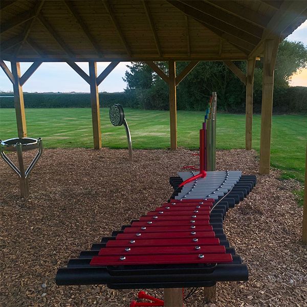 An outdoor xylophone featuring pink and silver notes is located at the Thomas Centre Music Pavilion