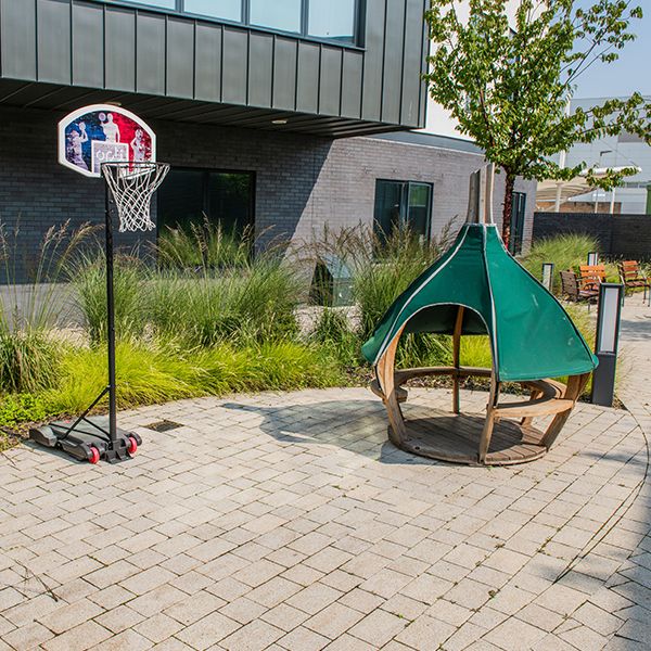 a basketball hoop and children's teepee in a children's hospital garden