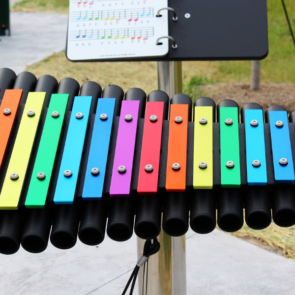 close up rainbow colored notes of an outdoor xylophone