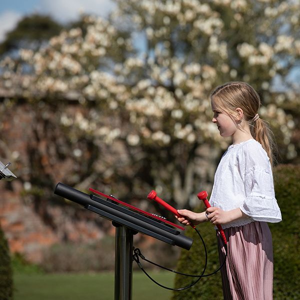 young girl playing an outdoor xylophone in the grounds of north cadbury court