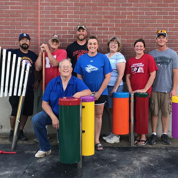 Eight volunteers from Pleasanton Lions Club standing behind the four outdoor musical instruments they have installed in the school playground