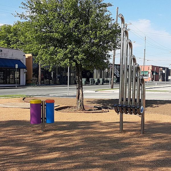 tall outdoor aerophones and drums in the Harmony Park at Sherman Public library