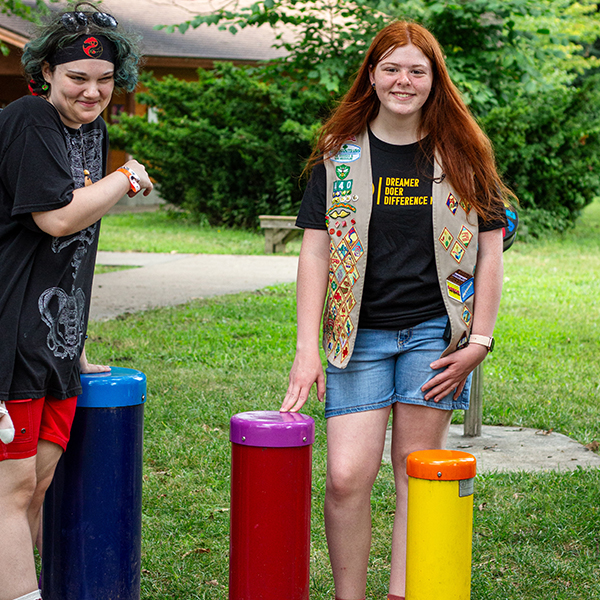 gold scout award winner Paige Thomas playing colorful outdoor drums in her percussion park at Lees Summit Rotary Camp 