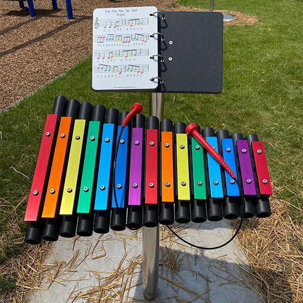 a large colorful outdoor xylophone with a music book