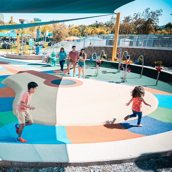 children running around the giant guitar on the floor of the sesame street music park in seaworld