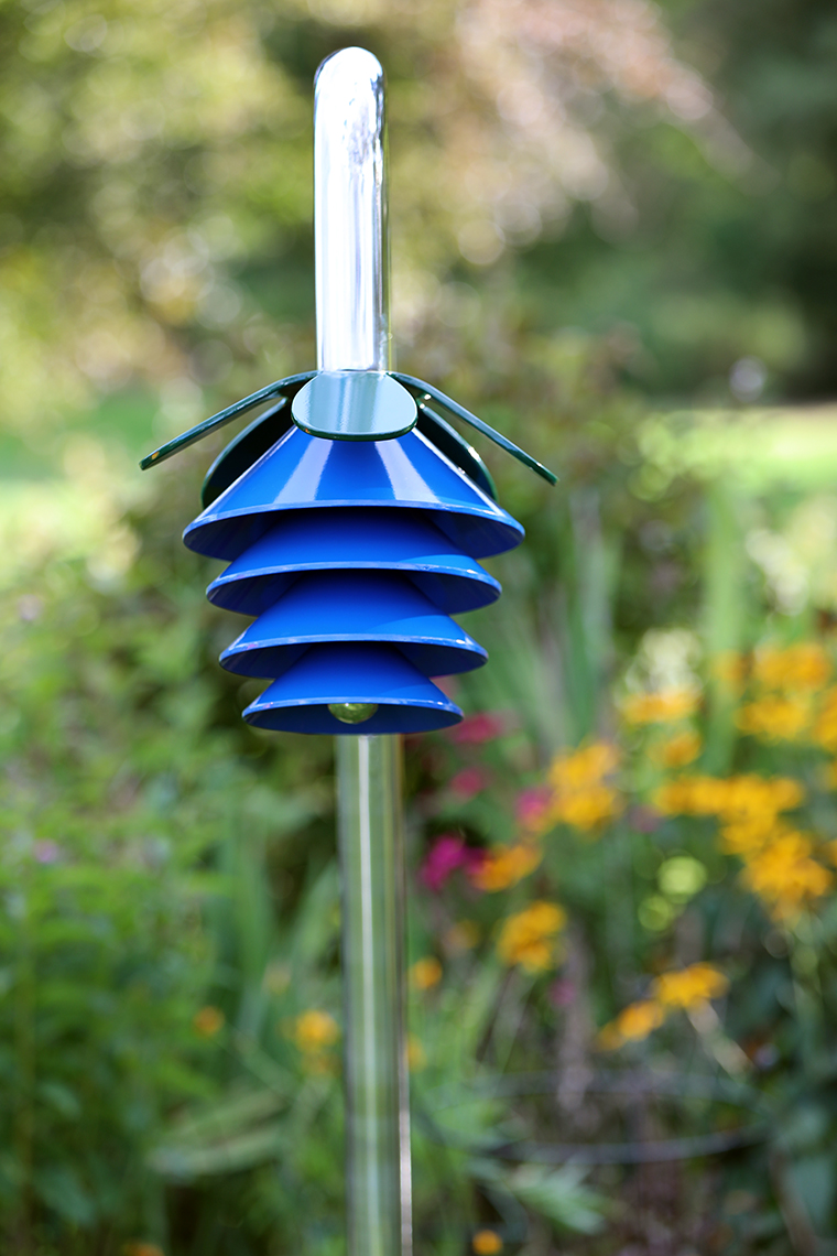 An outdoor musical flower comprising four blue bells and a petal on a stainless steel 'stalk' for playgrounds and sensory gardens
