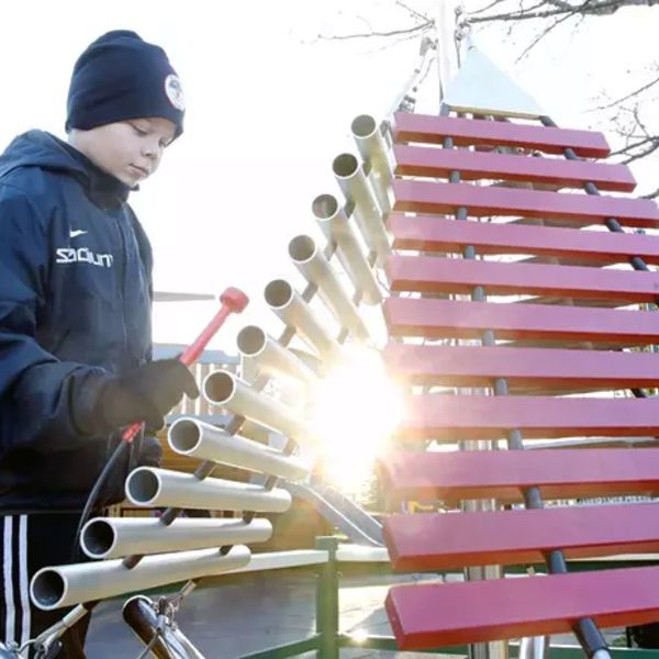 Outdoor xylophone with three sets of keys cascading from one central post in a music park in Finland