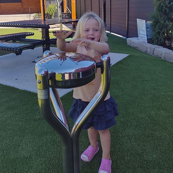 a young girl playing an outdoor stainless steel tongue drum in the Madison Childrens Museum