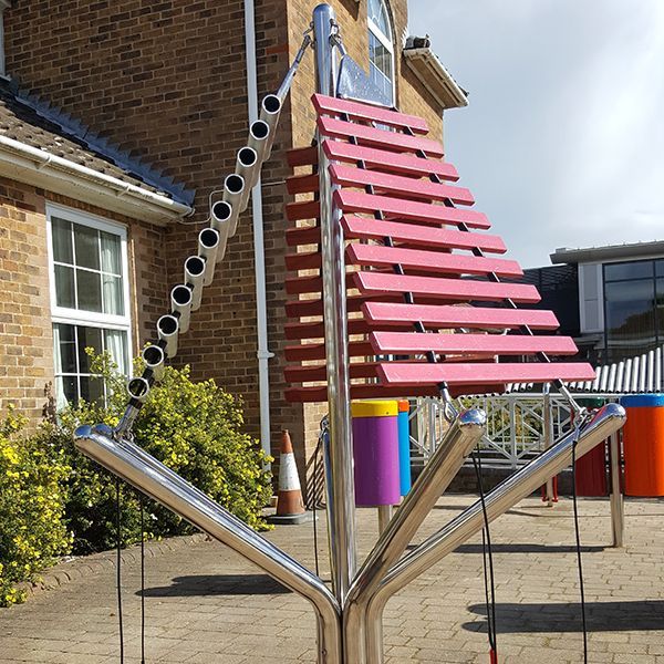 large musical instruments with cascading xylophones on three side in a playground