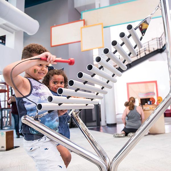 two young children playing on the musical instrument in the creativity jam area at the minnesota children's museum