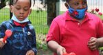 School children from the Lift For Life Academy playing colorful outdoor xylophone in their schoolyard