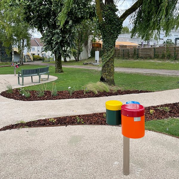 a colourful set of three small outdoor bongo drums on a stainless steel post installed on a pathway