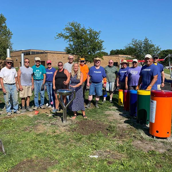 Hastings Noon Kiwanis team standing next to a recently completed outdoor musical playground in the Lincoln Elementary School Playgound