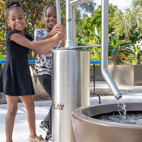 Tow girls playing on a water play structure at the Florida botanical gardens