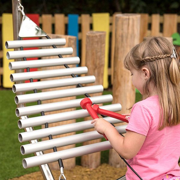 Young girl playing an outdoor musical instrument in Denzils Music Mayhem Outdoor Musical Park at West Midlands Safari Park