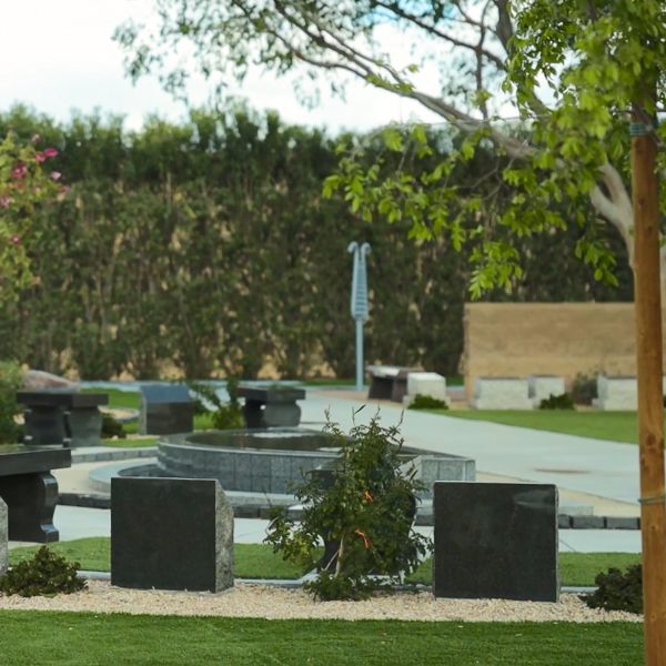 a view across the Hansens Memorial Garden with a bell lyre outdoor musical instrument in the background