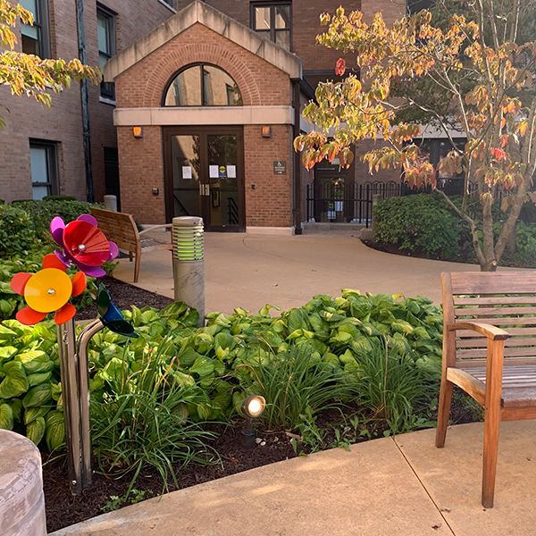 outdoor musical flowers next to a bench in the laclede groves senior living facility