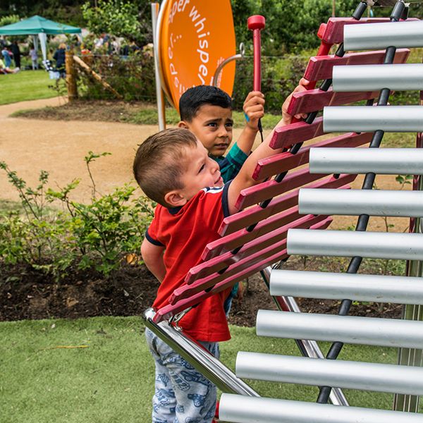 two small boys playing a large outdoor musical instrument in the playful garden at Brodie Castle National Trust Scotland