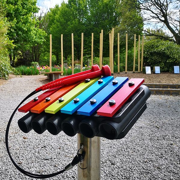 a small rainbow colored metallophone in the grounds of sir harold hilliers gardens