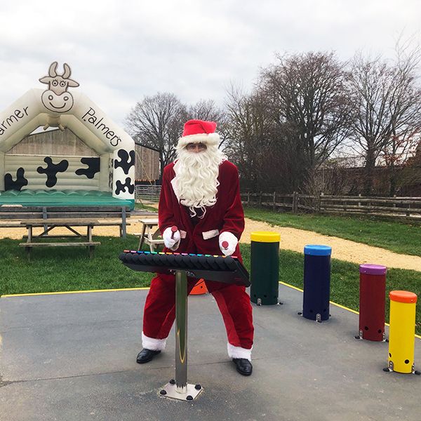 image of Father Christmas playing outdoor musical instruments at Farmer Palmers Farm Park