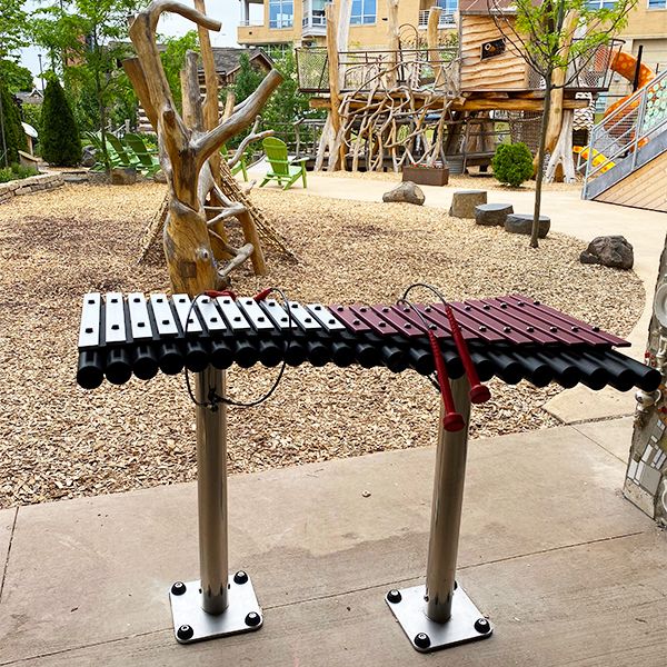 a large outdoor xylophone with half silver and half pink keys at the Madison Childrens Museum wonderland playground