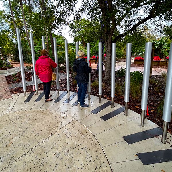 Two Ladies Playing Huge Outdoor Musical Chimes in the Florida Botanical Garden Sensory Garden 