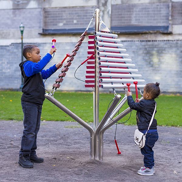 boy and girl playing a large outdoor xylophone in a park