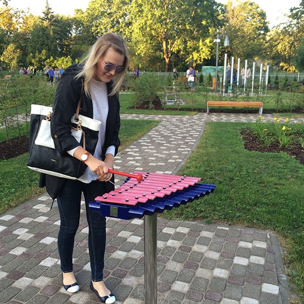 Young lady playing an outdoor xylophone from Percussion Play