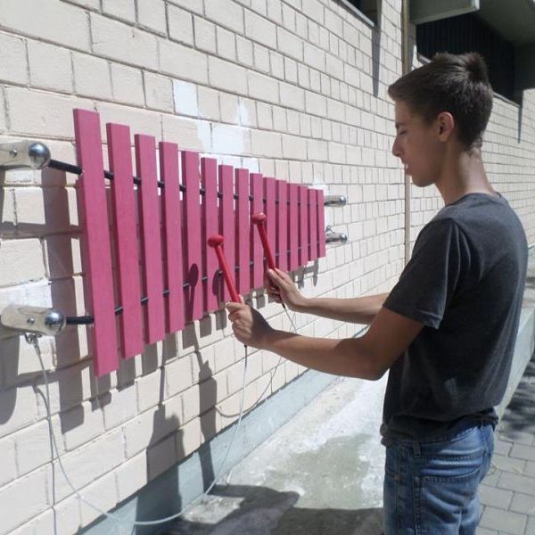 boy playing wall mounted marimba xylophone outside Tel Aviv Music Centre