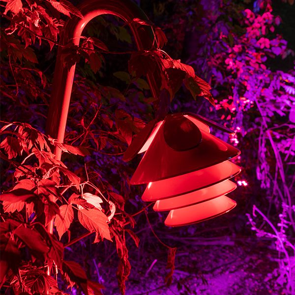 A musical flower bell in a sculpture garden lit up in red lights