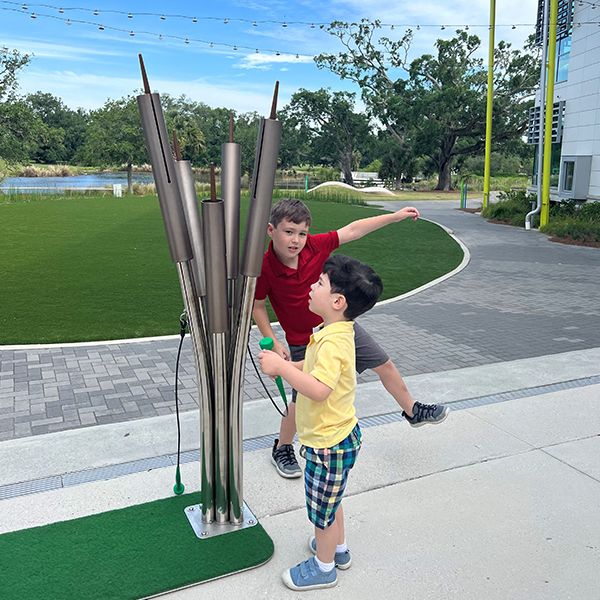 two young boys playing on an outdoor musical instrument at the Louisiana Children's Museum