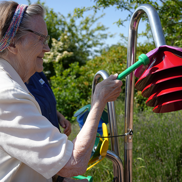senior lady playing outdoor musical flower in a senior living home