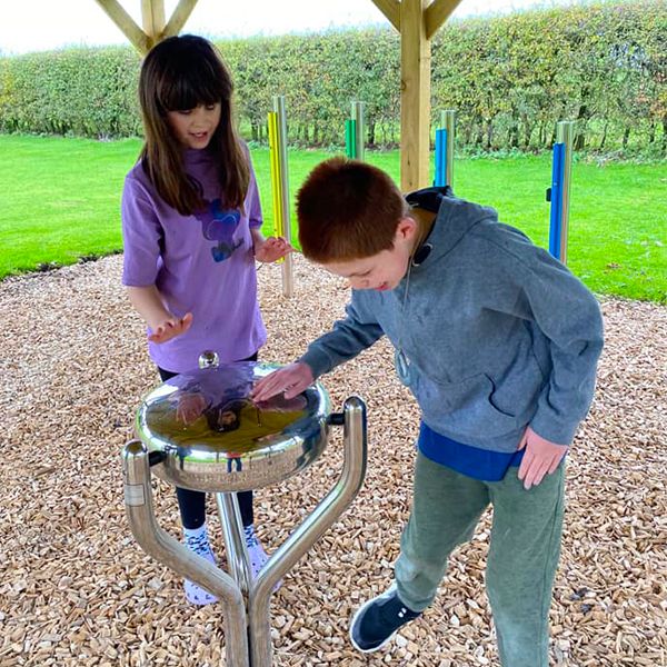 Boy and girl playing a steel drum outdoors at the Thomas Centre