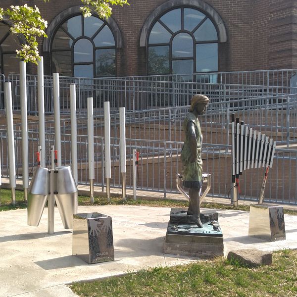 outdoor musical instruments installed next to the sidewalk outside the Oil City Library