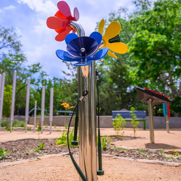 a large outdoor musical instrument that looks like three flower heads and played with a mallet