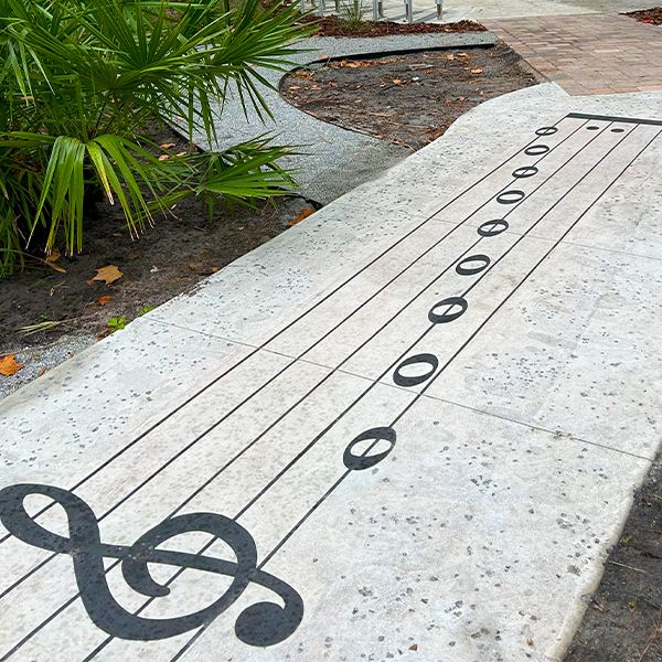 a pathway with a treble clef and musical notes  in the botanical gardens florida