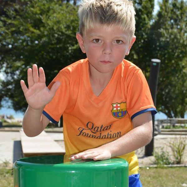 boy playing colourful outdoor drum in playground