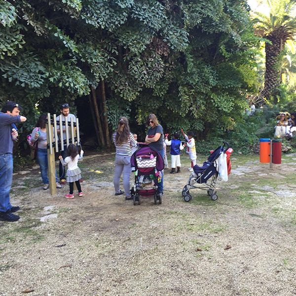 families gathered around large outdoor musical instruments in play park