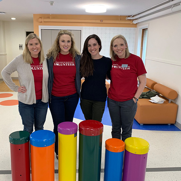 5 female staff from the children's healing center standing behind the new outdoor drums ready to be installed