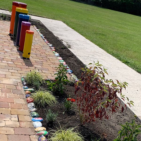 Rainbow coloured outdoor musical drums in a school memorial garden created for a former student