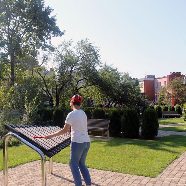 young person in a cap playing a huge outdoor marimba from Percussion Play