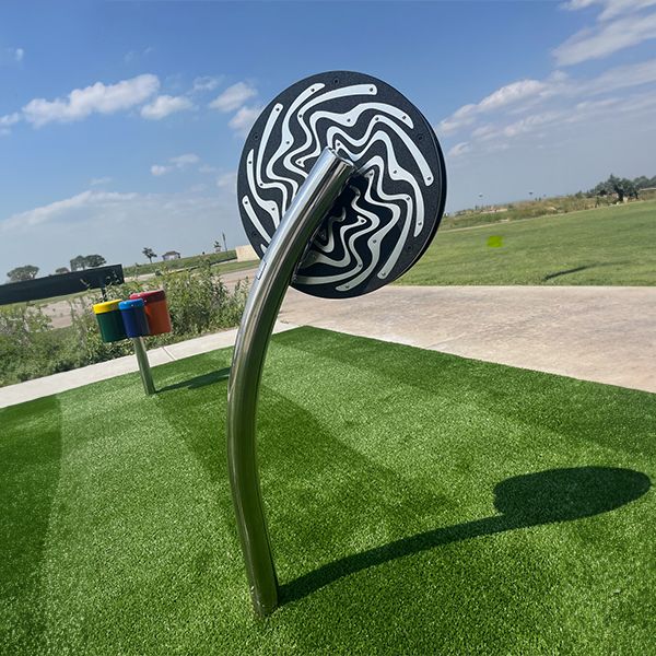 a circular rain wheel on a stainless steel post in the Kansas Wetlands Center new musical garden