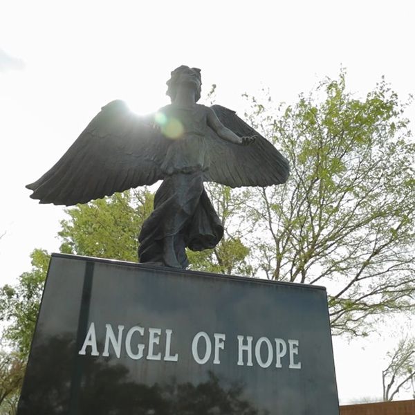 A statue of an angel with the word angel of hope engraved on the base