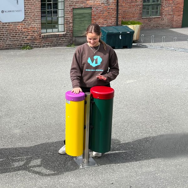 female teenager playing outdoor musical drums outside the Vitensenteret Innlandet Science Centre in Norway