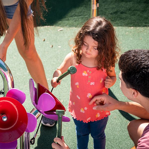 a young girl playing outdoor musical flowers with her father at the sesame street music park in seaworld