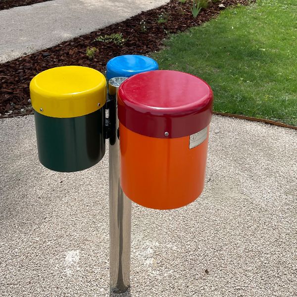 a colourful set of three small outdoor bongo drums on a stainless steel post installed on a pathway