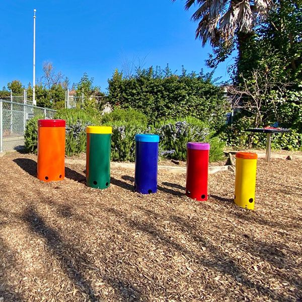 five rainbow colored outdoor musical drums for in a school playground